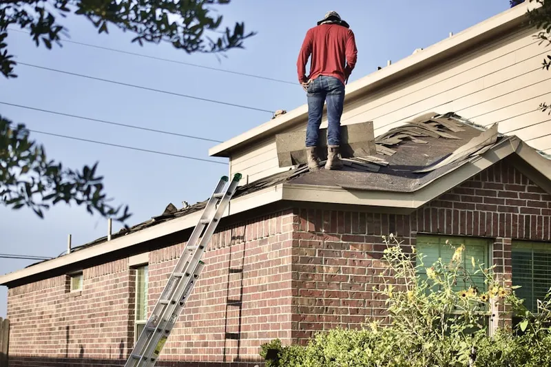Professional roofer working on a residential roof in North End